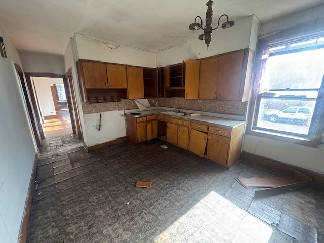 kitchen featuring backsplash, a notable chandelier, and sink