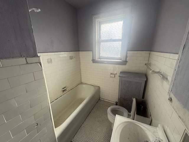 bathroom with tile patterned floors, radiator, tile walls, toilet, and a bathing tub