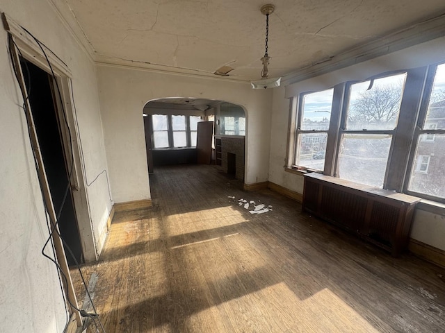 unfurnished sunroom featuring radiator heating unit and a brick fireplace