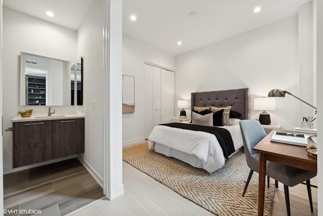 bedroom featuring light hardwood / wood-style floors and sink