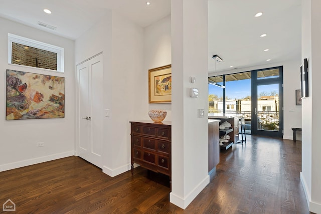 corridor with floor to ceiling windows and dark wood-type flooring