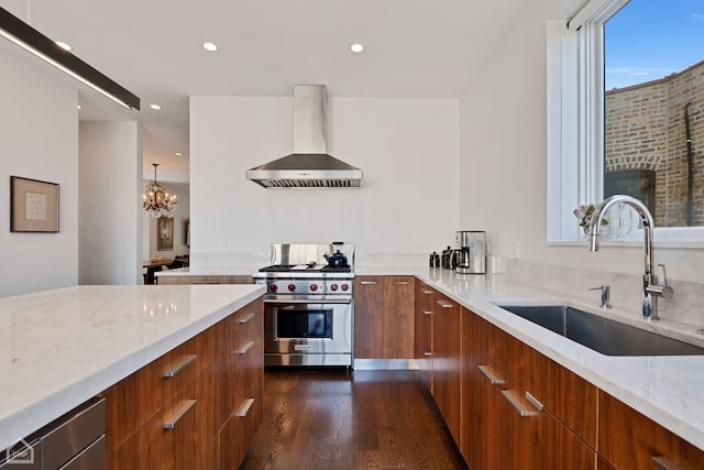 kitchen with an inviting chandelier, wall chimney range hood, sink, luxury range, and a fireplace