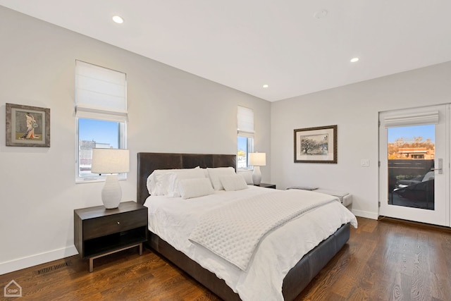 bedroom with dark hardwood / wood-style floors and multiple windows