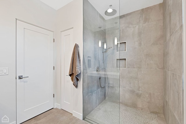 bathroom featuring tile patterned flooring and a shower with shower door