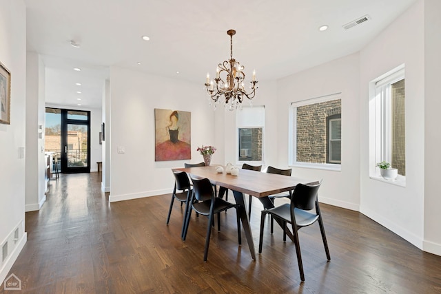 dining space with a notable chandelier and dark hardwood / wood-style floors