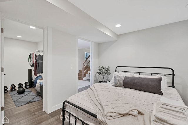 bedroom with hardwood / wood-style flooring, a walk in closet, and a closet