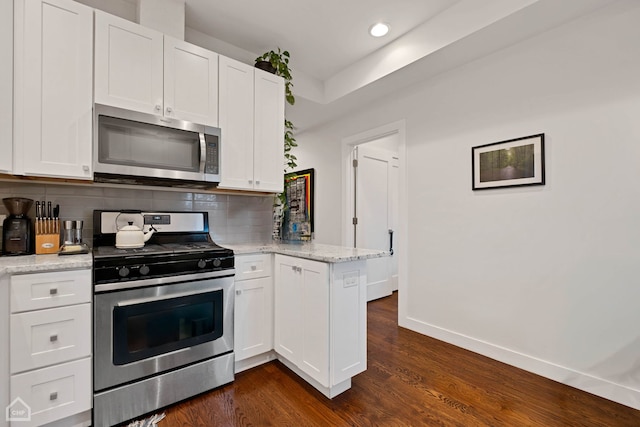 kitchen with light stone counters, white cabinetry, appliances with stainless steel finishes, and tasteful backsplash