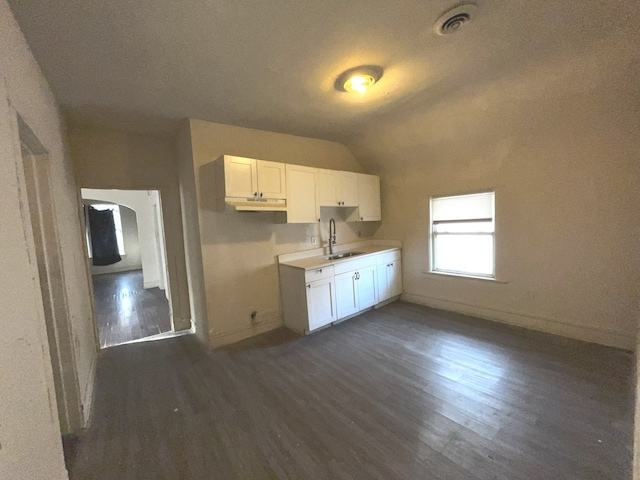 kitchen with white cabinets, dark hardwood / wood-style floors, sink, and vaulted ceiling