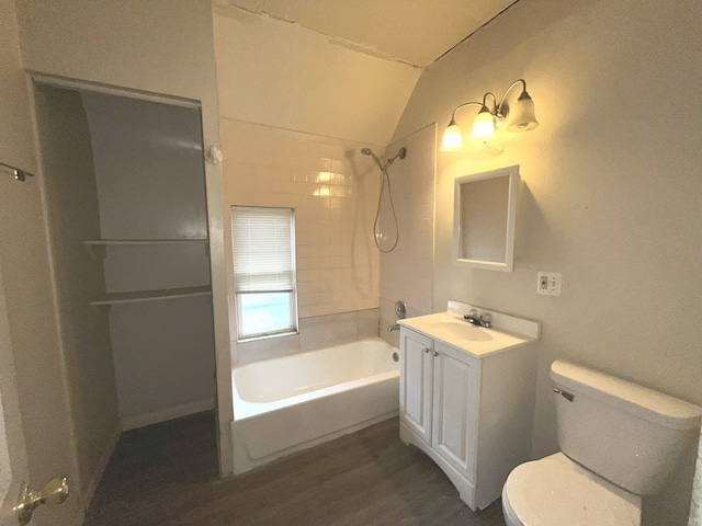 full bathroom featuring vanity, tiled shower / bath combo, vaulted ceiling, hardwood / wood-style flooring, and toilet