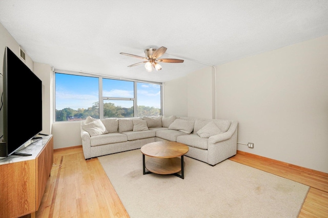 living room featuring light hardwood / wood-style flooring and ceiling fan