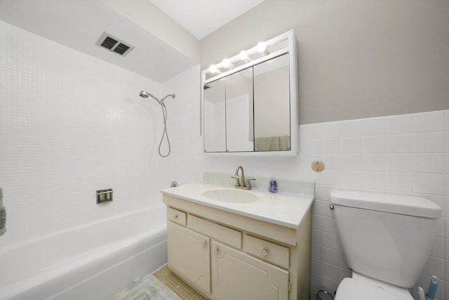 full bathroom featuring vanity, tile walls, tile patterned flooring, toilet, and tiled shower / bath