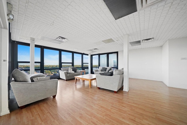 living room featuring floor to ceiling windows and light wood-type flooring