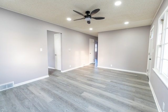 unfurnished room with ceiling fan, a textured ceiling, and light hardwood / wood-style floors