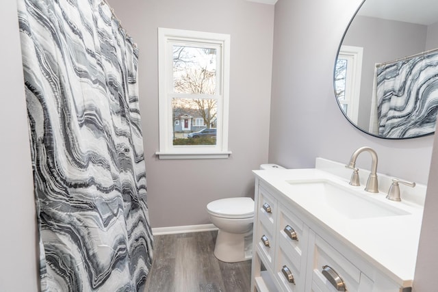 bathroom featuring vanity, hardwood / wood-style floors, toilet, and a healthy amount of sunlight