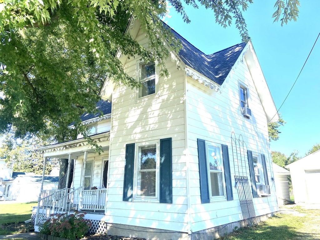 view of side of home featuring covered porch