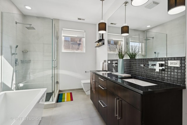 full bathroom featuring toilet, tile patterned floors, vanity, tasteful backsplash, and shower with separate bathtub