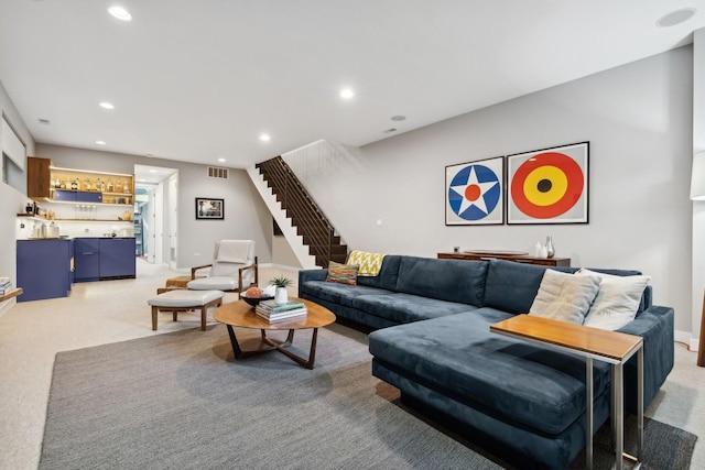 living room featuring bar area and light colored carpet