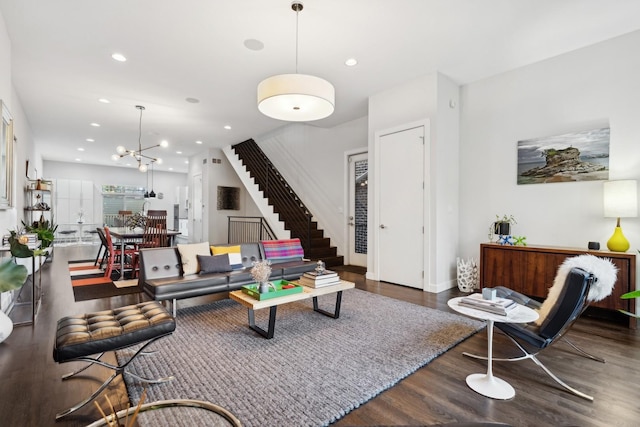 living room with a notable chandelier and dark hardwood / wood-style flooring