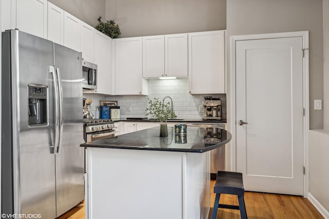 kitchen with a center island, sink, white cabinetry, and stainless steel appliances