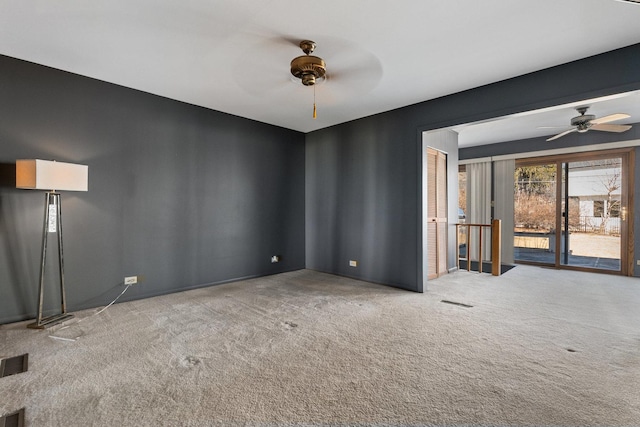 spare room featuring carpet floors, ceiling fan, and visible vents