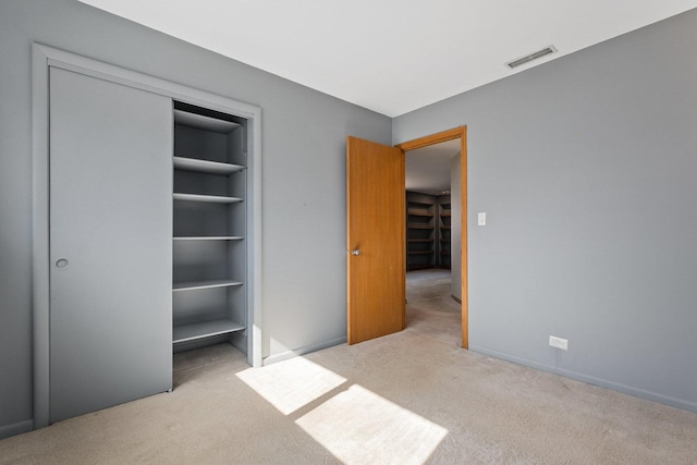 unfurnished bedroom with carpet floors, a closet, visible vents, and baseboards