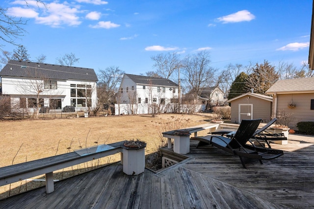 deck featuring a shed, fence, and an outbuilding