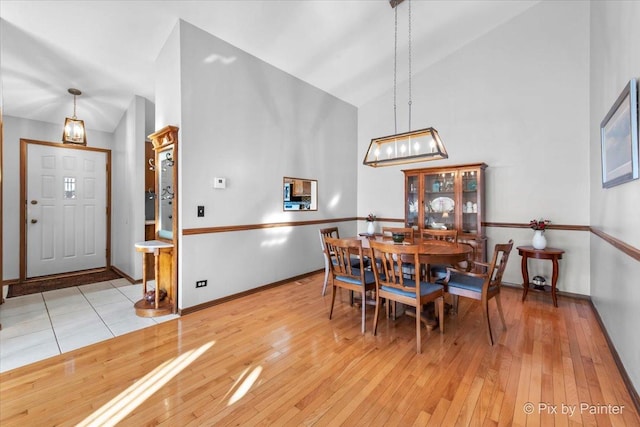 dining room featuring lofted ceiling and light wood-type flooring