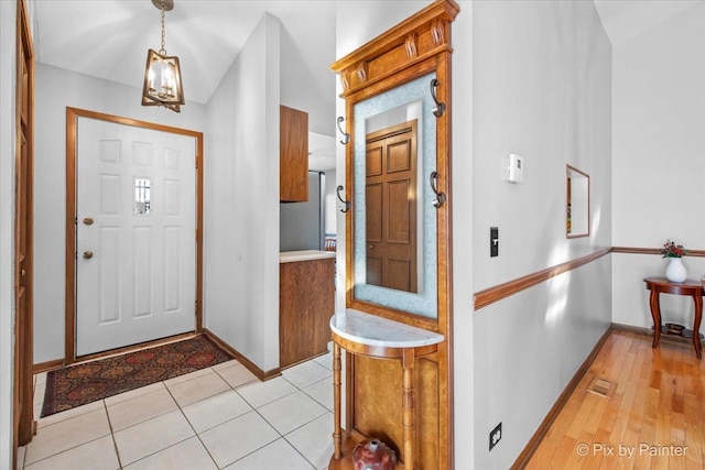 tiled foyer entrance with a notable chandelier