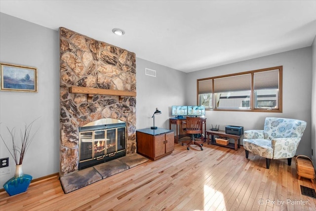 interior space with light hardwood / wood-style flooring and a stone fireplace