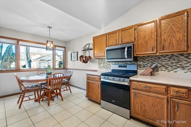 kitchen with stainless steel appliances, decorative light fixtures, vaulted ceiling, backsplash, and a chandelier