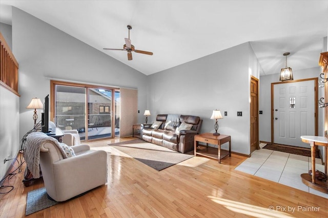 living room featuring light hardwood / wood-style floors, ceiling fan, and high vaulted ceiling