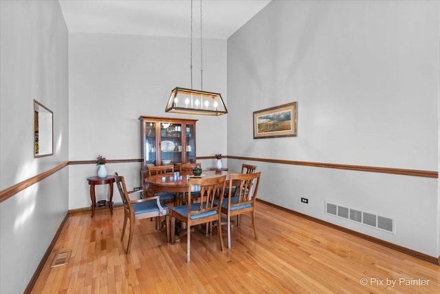 dining room with wood-type flooring and vaulted ceiling