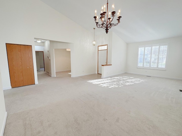 unfurnished living room featuring a chandelier, light carpet, and high vaulted ceiling