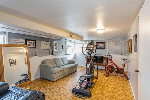 living room with light parquet floors and brick wall