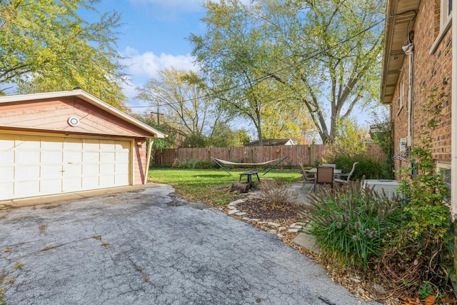 view of yard with an outbuilding, a garage, and a patio area