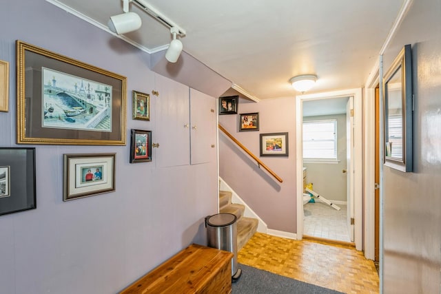 interior space featuring crown molding, light parquet flooring, and track lighting