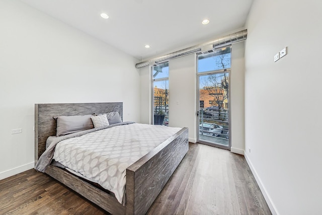 bedroom with dark hardwood / wood-style floors and access to exterior