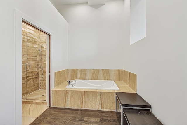 bathroom featuring plus walk in shower and hardwood / wood-style flooring