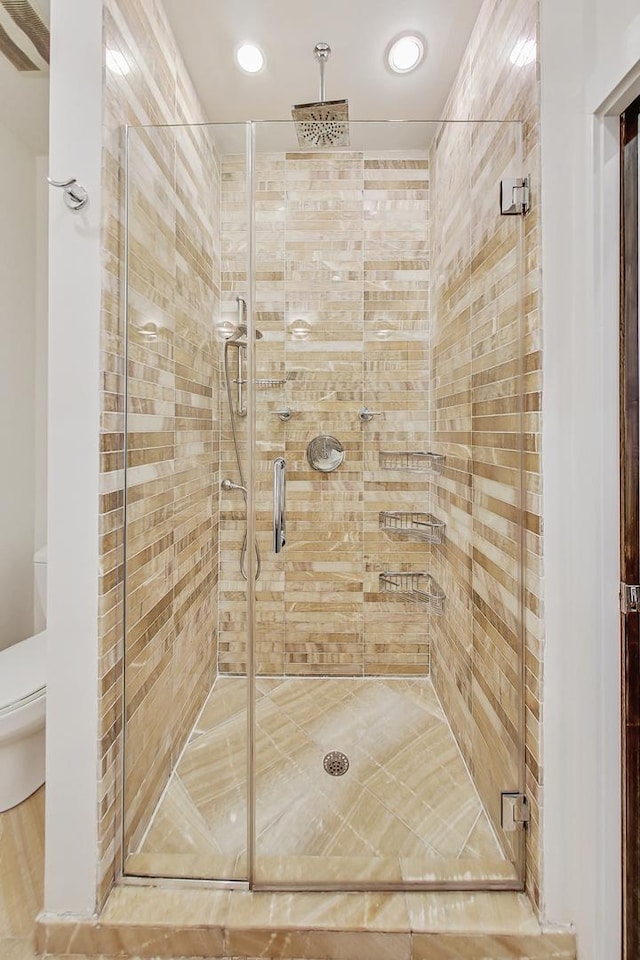 bathroom with an enclosed shower and toilet