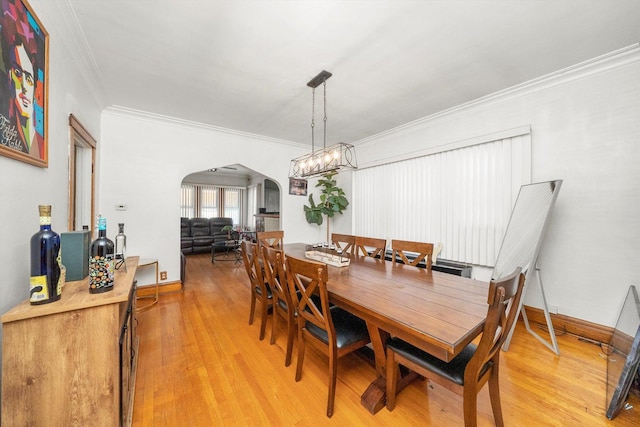 dining area featuring hardwood / wood-style floors, crown molding, and an inviting chandelier