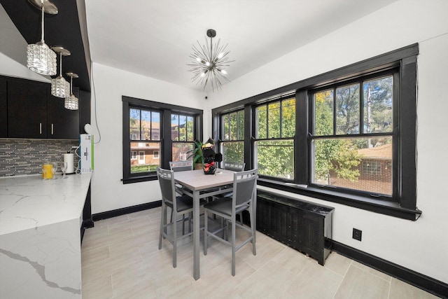 dining room featuring radiator and a notable chandelier