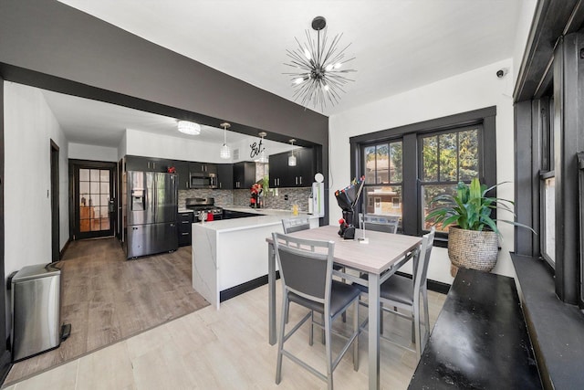 dining area with a chandelier and light hardwood / wood-style flooring