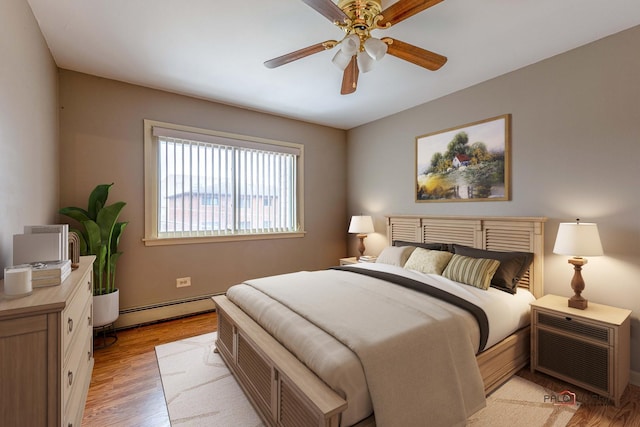 bedroom featuring light hardwood / wood-style flooring, baseboard heating, and ceiling fan