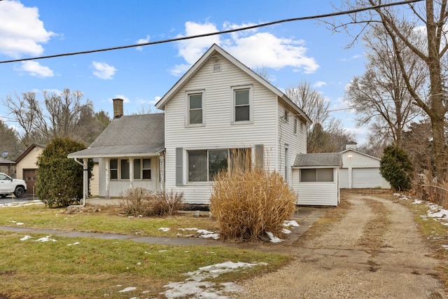 view of front of property with covered porch, a garage, and an outdoor structure