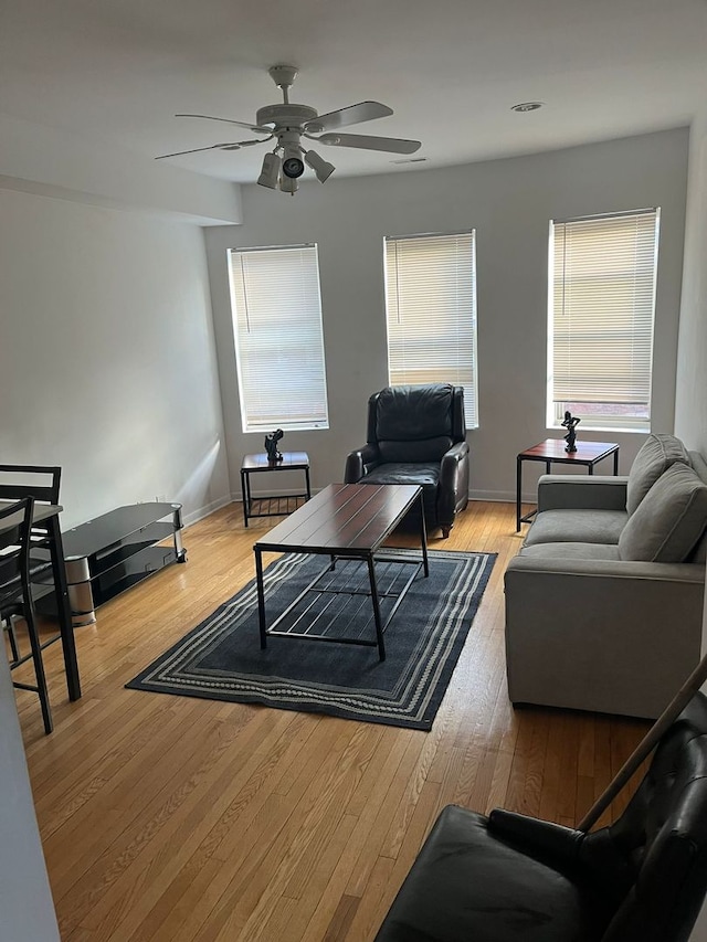 living room featuring light wood-type flooring and ceiling fan