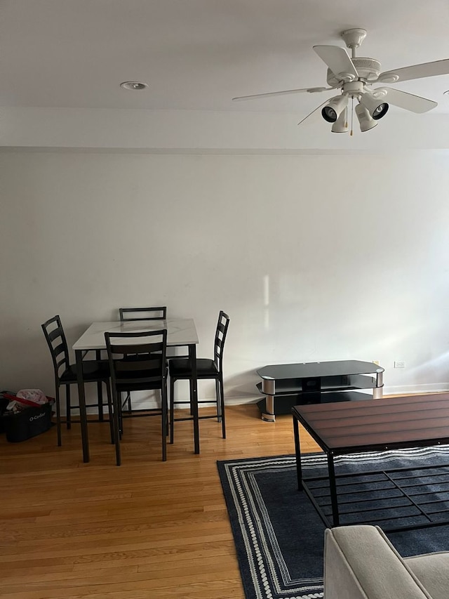 dining area with hardwood / wood-style flooring and ceiling fan