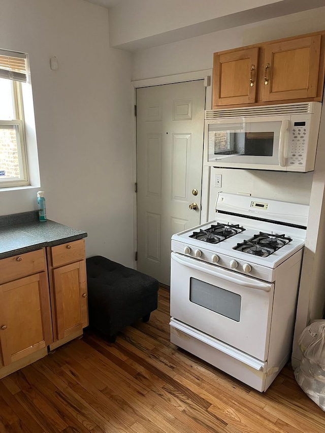 kitchen featuring white appliances and light hardwood / wood-style flooring