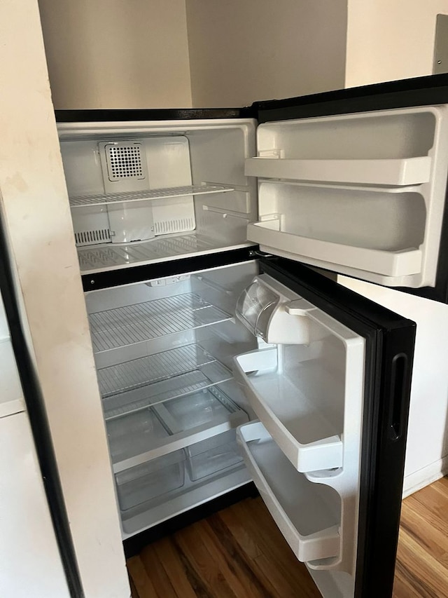 interior details featuring refrigerator and hardwood / wood-style flooring