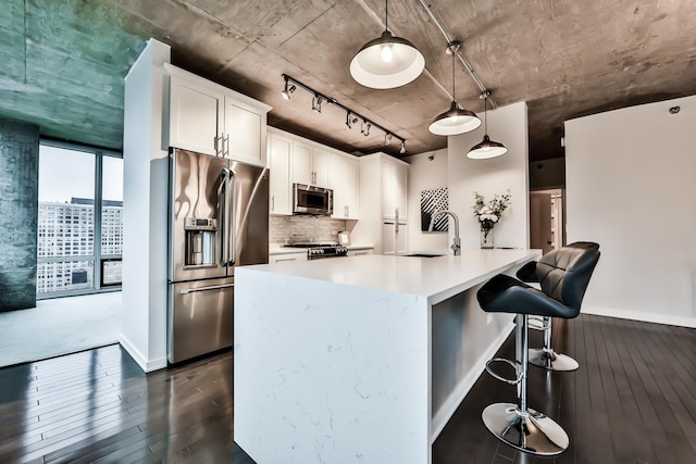 611 S Wells St Unit 1903, Chicago, IL 60607 - kitchen with stainless steel appliances, dark wood finished floors, tasteful backsplash, white cabinetry, and light countertops