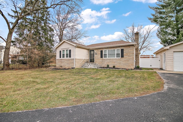 ranch-style house with a garage and a front lawn